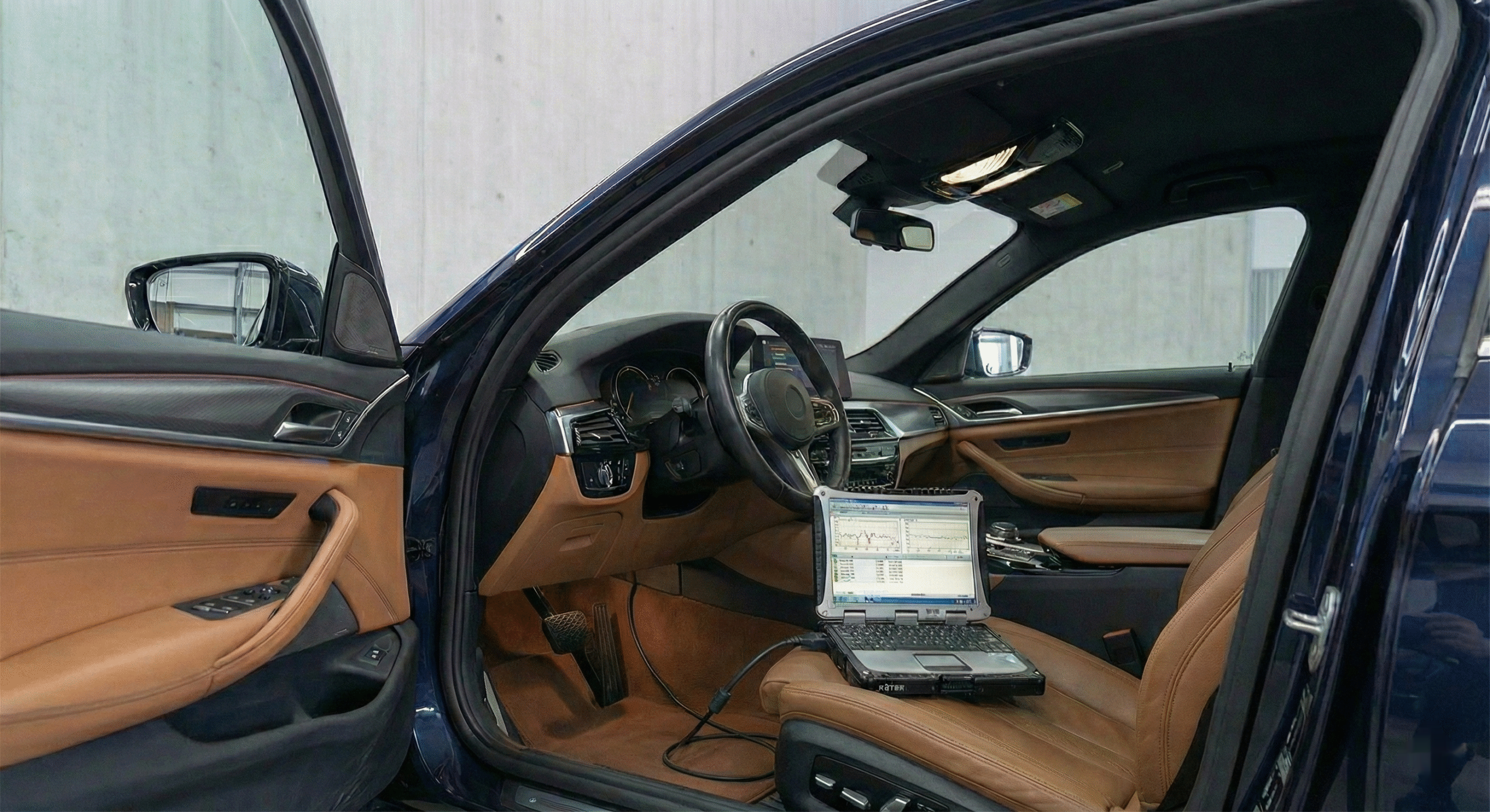 Diagnose-Laptop angeschlossen am OBD-Anschluss eines BMW im Radhaus Pforzheim — digitale Fahrzeugdiagnose und Werks-Codierung für BMW, Audi, VW und Mercedes-Benz